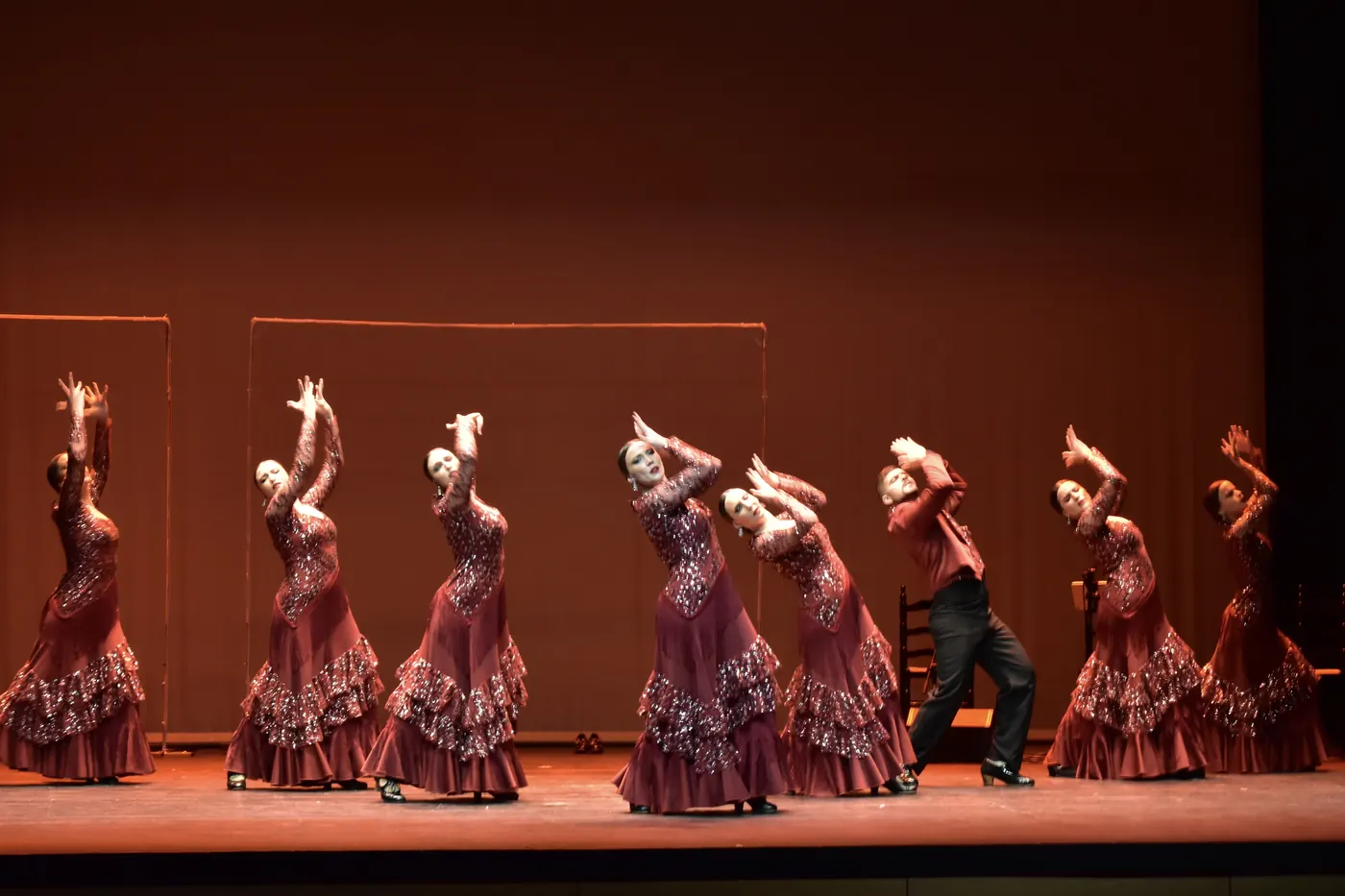 Bailaoras de Siete Notas con trajes rojos de brillantes, brazos en alto