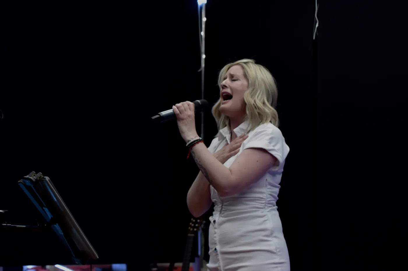Alumna cantando con vestido blanco en Siete Notas