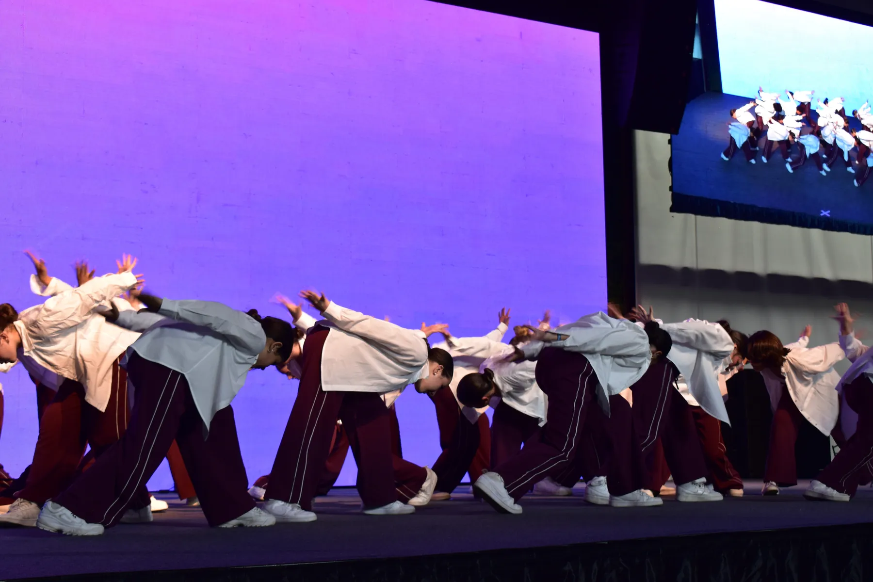 Gran grupo juvenil en una coreografía colectiva sobre el escenario